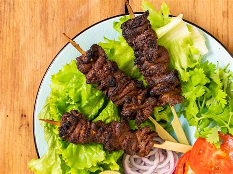  Suya! Een Ontzettend Lekker Gebraden en Gepijperd Vleesgerecht Met een Rokerige Umami Smaak